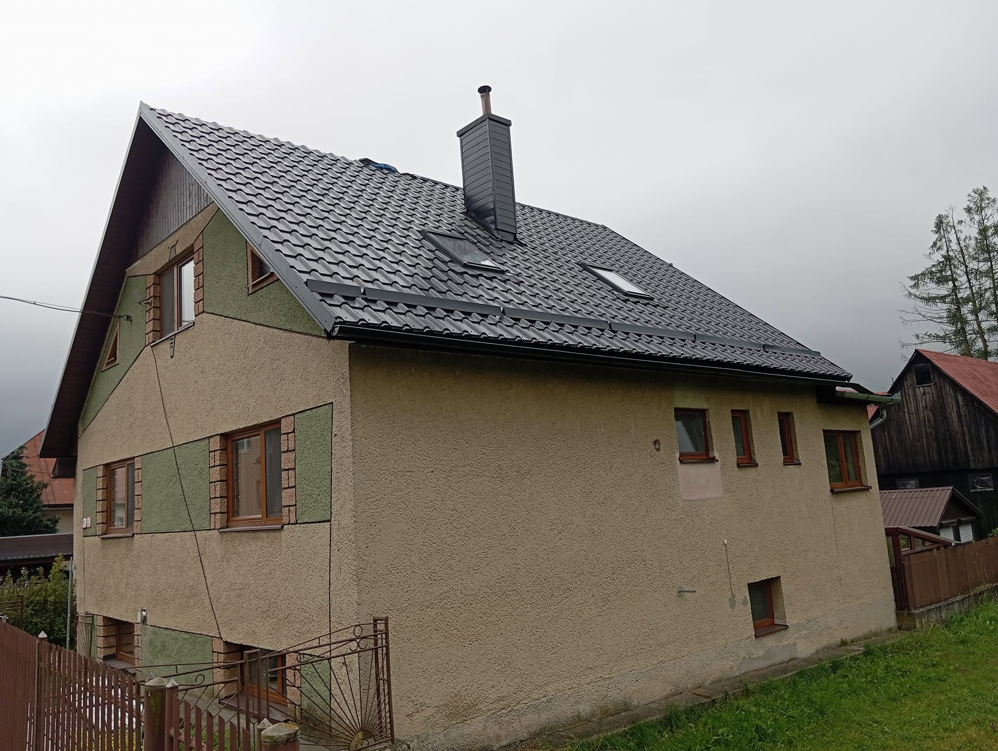 Starší rodinný dom s tmavou strechou a strešným oknom — typický dom na obnovu, Orava